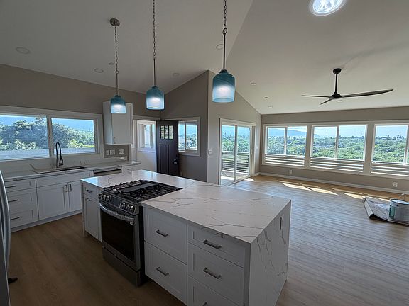 Vaulted living room and kitchen with Kaena Pt. ocean and Mt. Kaala views