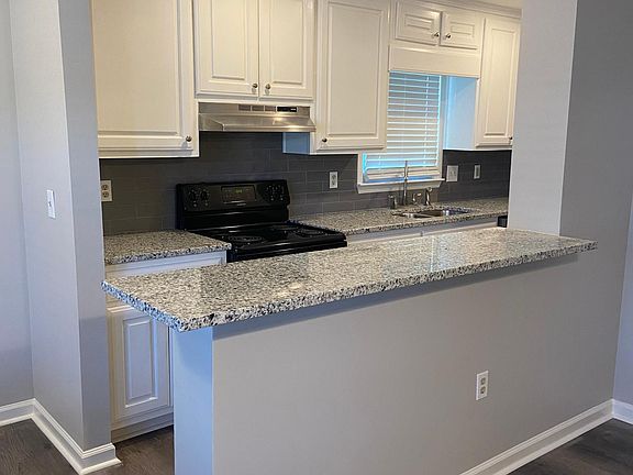 Kitchen with granite countertop open to living area