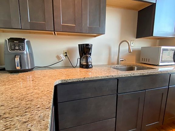 New rich grey cabinets with granite counters. Refrigerator, gas stove and microwave included.