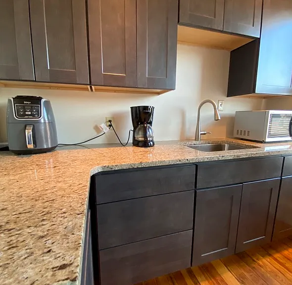 New rich grey cabinets with granite counters. Refrigerator, gas stove and microwave included.