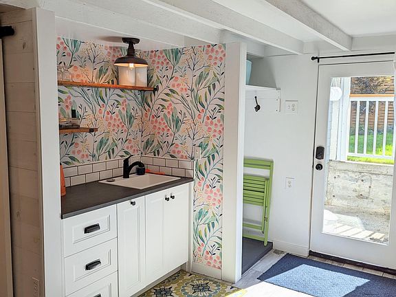 Entryway coat closet and kitchen sink/prep area.