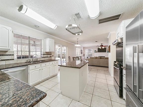 This awesome kitchen can be entered from the formal dining room and also the entry hallway. This room is light and bright and boasts neutral tile flooring, gorgeous granite countertops, coordinating backsplash with decorative tile inserts and stainle