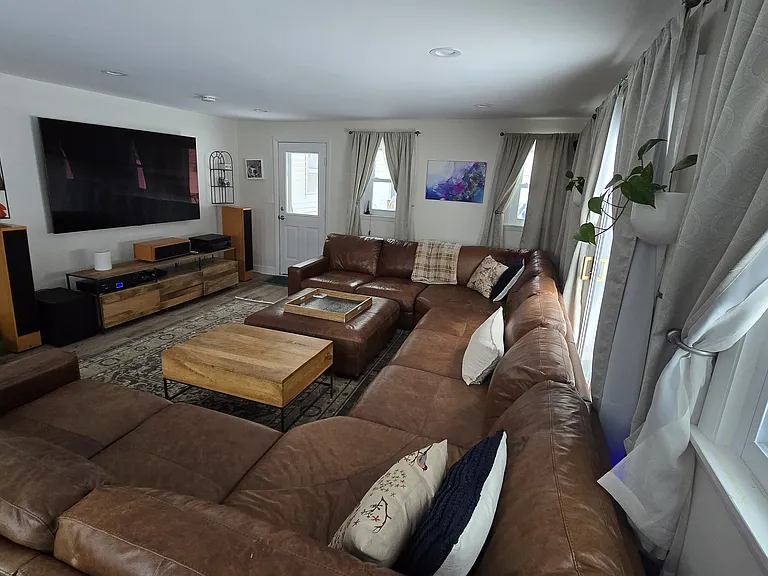 Family Room with oversized leather sectional sofa (easily seats 8-10) & ottoman. 85" TV & TV console.
