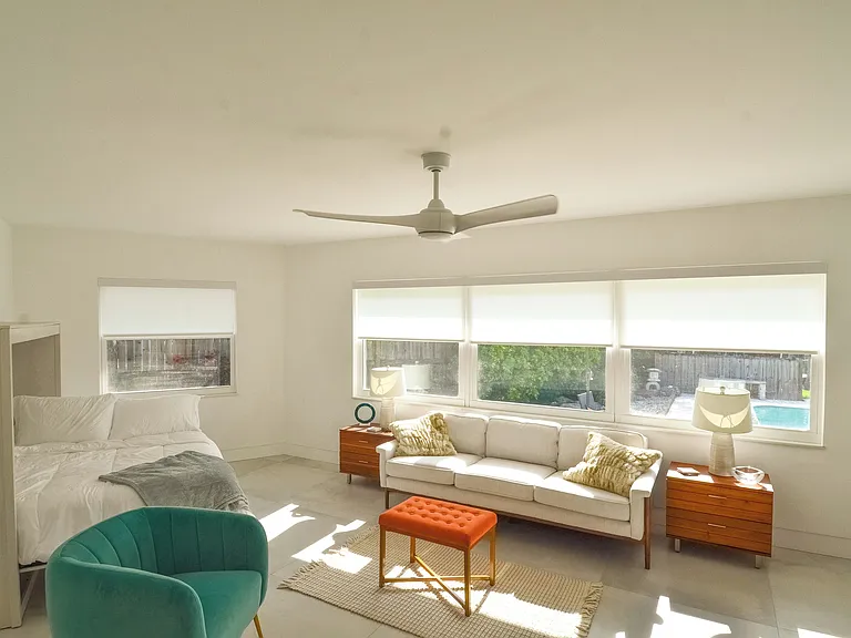 Sunroom with coach, murphy bed and desk. Easy access via sliding glass door to the screened in porch