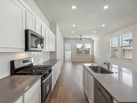 Kitchen in the Cedar home plan by Trophy Signature Homes - REPRESENTATIVE PHOTO