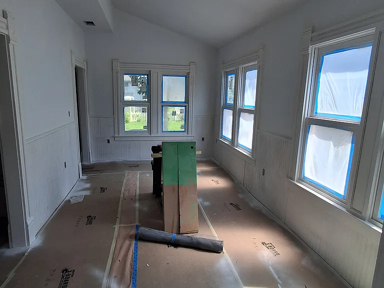 Dining room with freshly primed beadboard trim. The walls will be various pastel shades, so the beadboard will pop. The original floor will be restored.