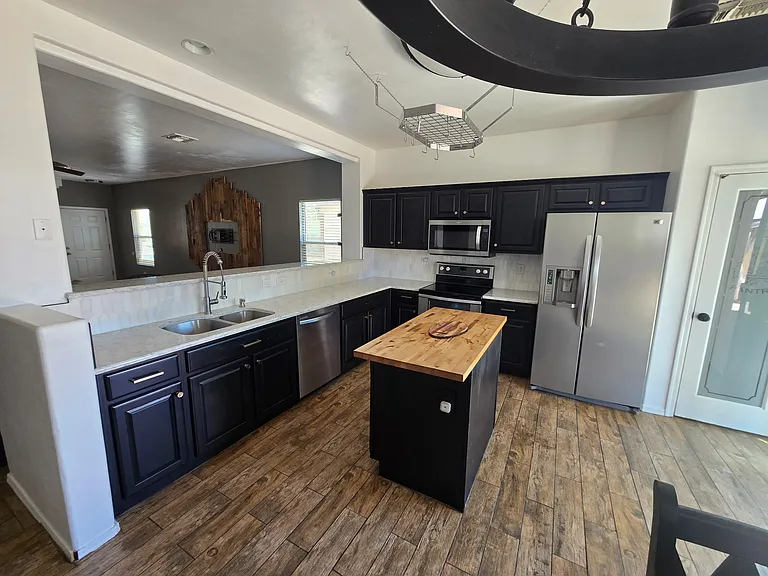Kitchen with granite counter tops, butcher block island and redone cabinets.