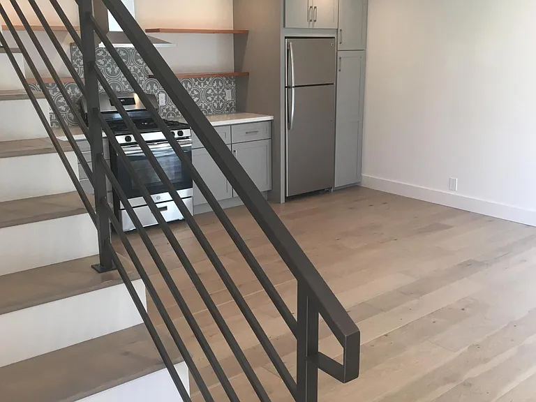 Lower level modern kitchen and staircase to the upstairs.