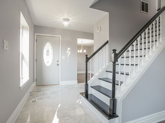 Foyer with marble tile and beautiful hardwood stairs leading to the bedrooms upstairs