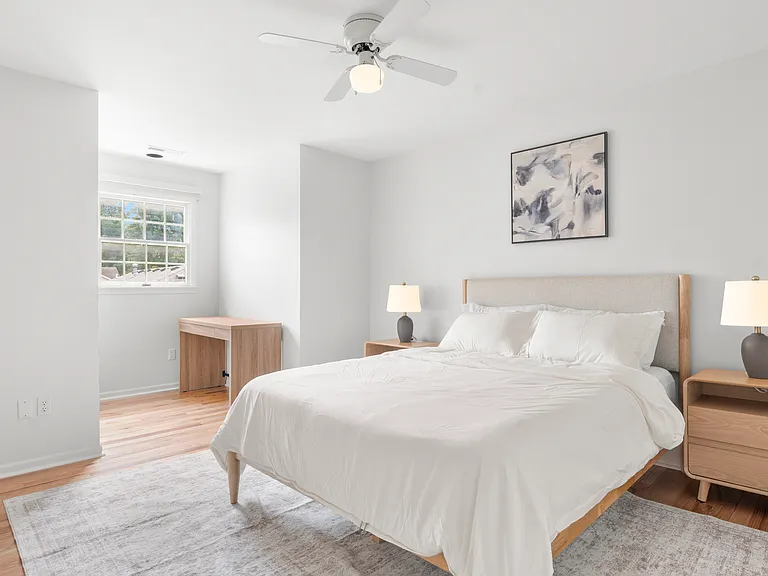 Inviting upper-level queen bedroom with clean linens, comfortable furnishings, and a dedicated writing desk.