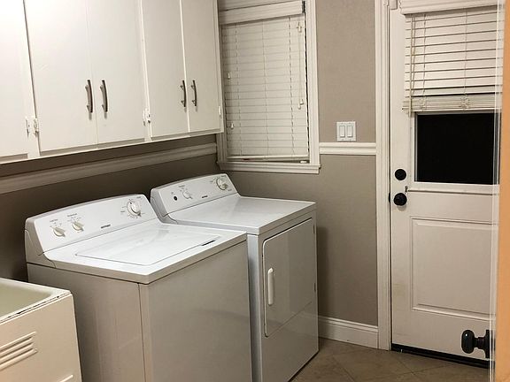 Laundry room w/utility sink, built in ironing board and patio access.