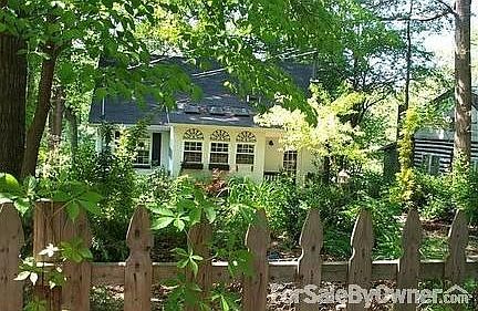 Front of House : lush exotic plants, low maintence yard & small picket fence ideal to contain pet