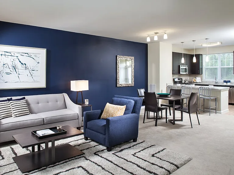 Renovated Package I kitchen, living, and dining areas with carpet