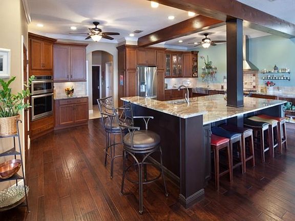 Kitchen with massive granite island and stainless appliances and