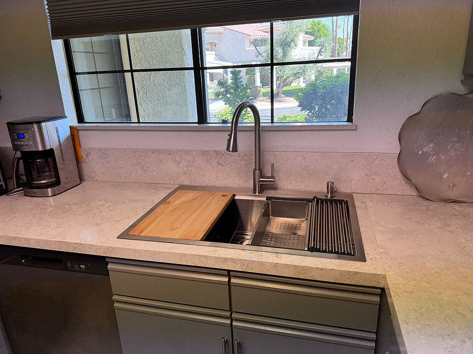 New food prep stainless steel sink with colander, cutting board, drain rack.