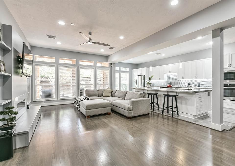 Open concept living with recent remodel features refinished hardwood flooring and concrete tile flooring in the kitchen. This photo shows a view to the recently redesigned back yard.