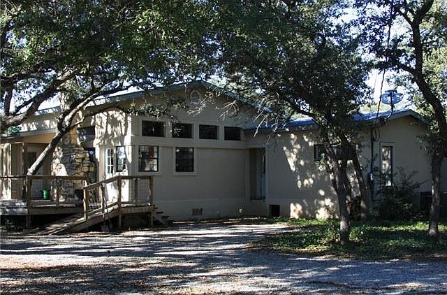 View of home from side.  Ramp and stairs lead off deck.