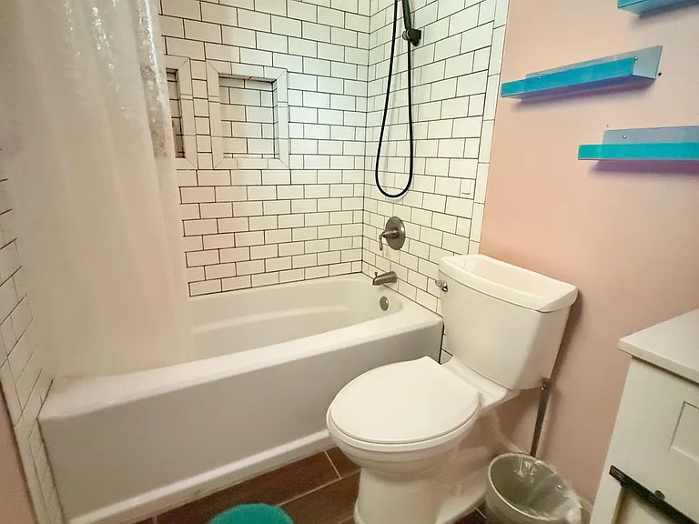 Full bathtub and shower with updated features, including upgraded shower head.