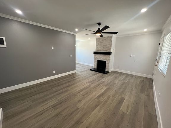 Living room with fireplace and dimmable Canlite's as well as ceiling fan