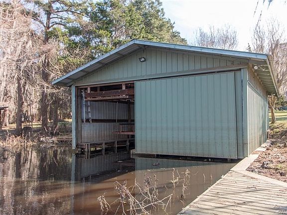 Double boathouse with electric lifts and barn door. From this view you can also note the seawall and additional decking for loading friends and family for a sunset cruise. This boathouse offers a wealth of storage for toys and accessories.