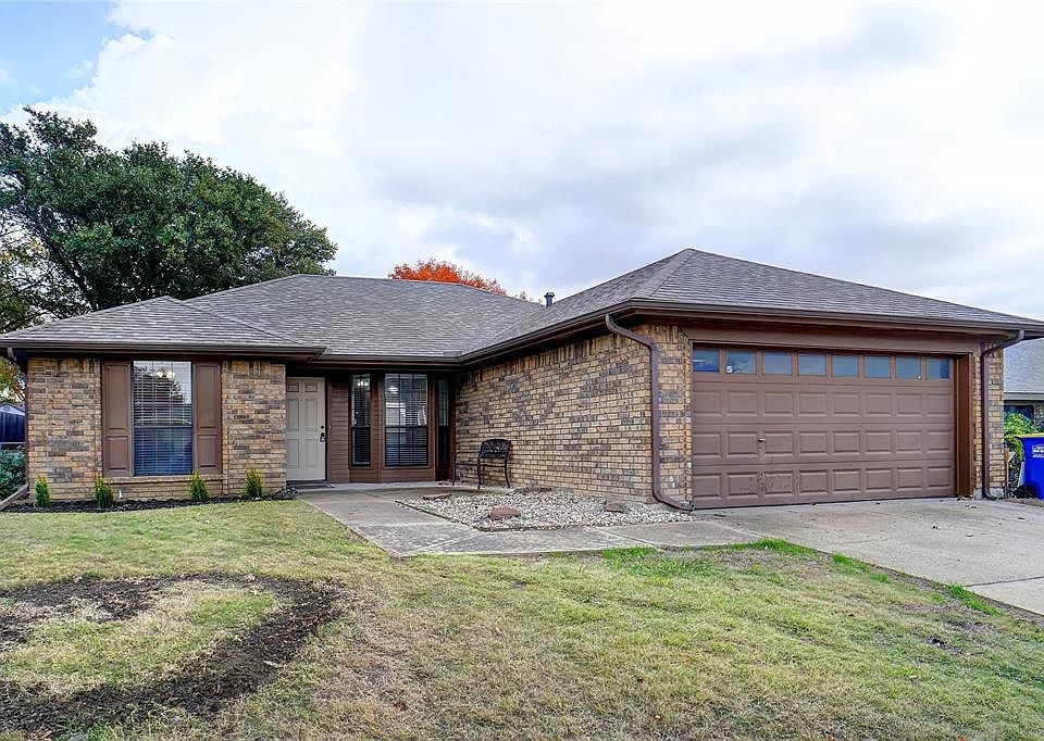 View of front of house featuring a front yard and a garage