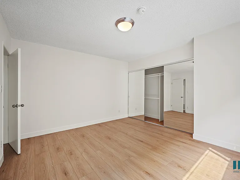 Bedroom with a Mirrored Closet and Vinyl Flooring