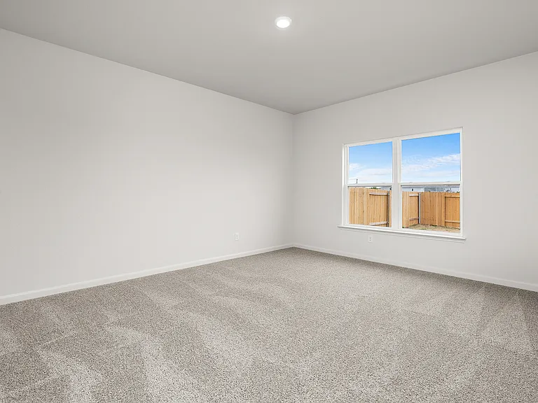 The master bedroom has a large window that lets in natural light and backyard views.
