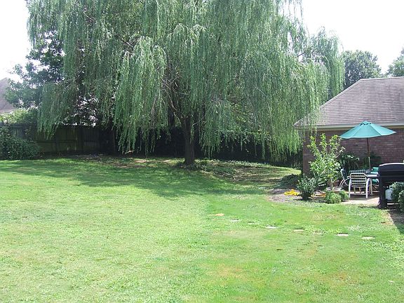 Wood fenced yard with double gate and storage building.