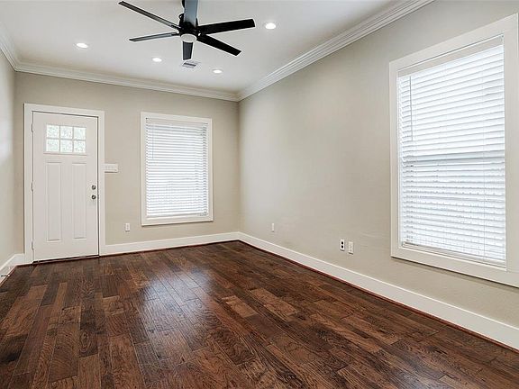 Spacious living room with hickory wood floors and 2 inch blinds.