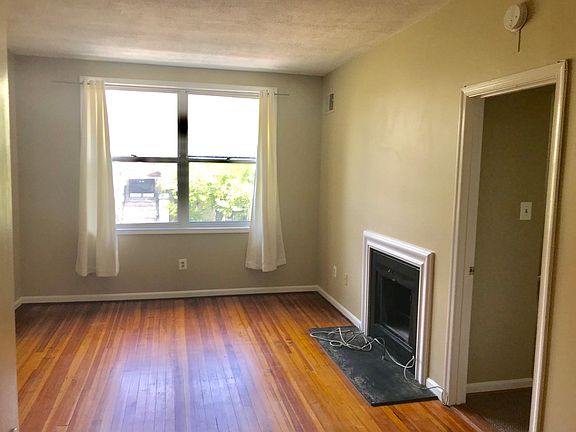 Living room (vacant) with big front, facing windows.
