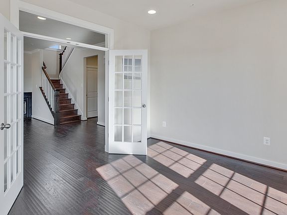 Light and bright study with French doors and transom, large double window, medium toned wood floors,