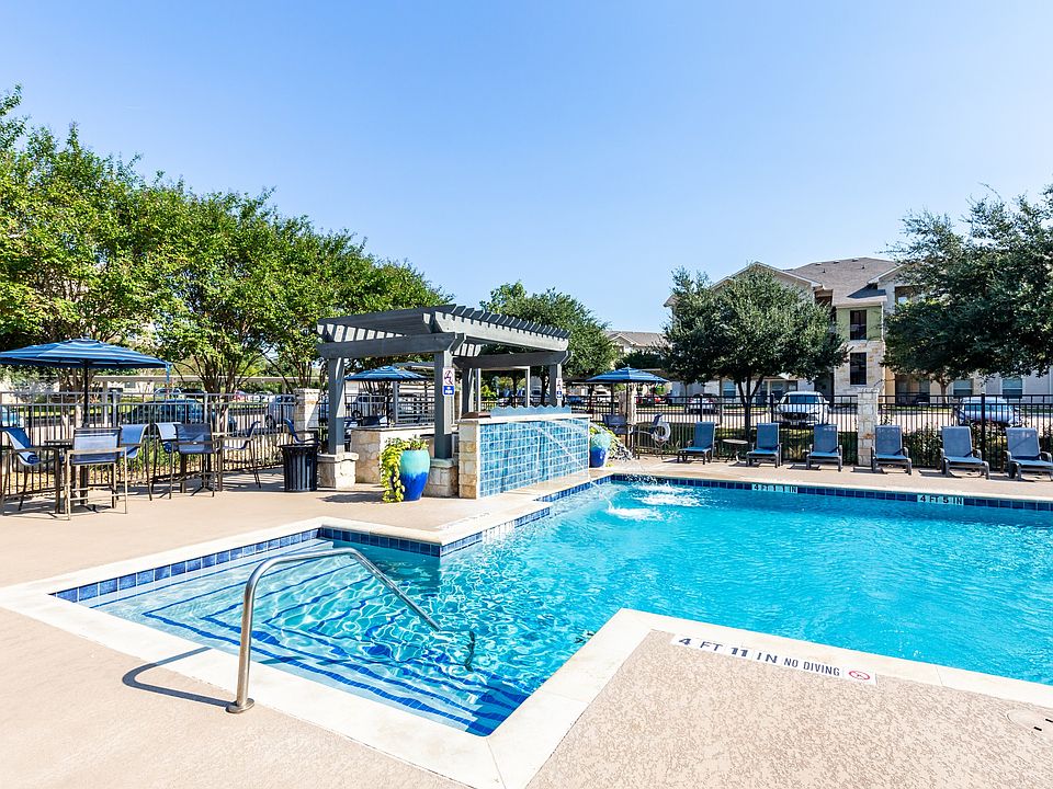 Lavish pool deck with serene water feature and lounge seating