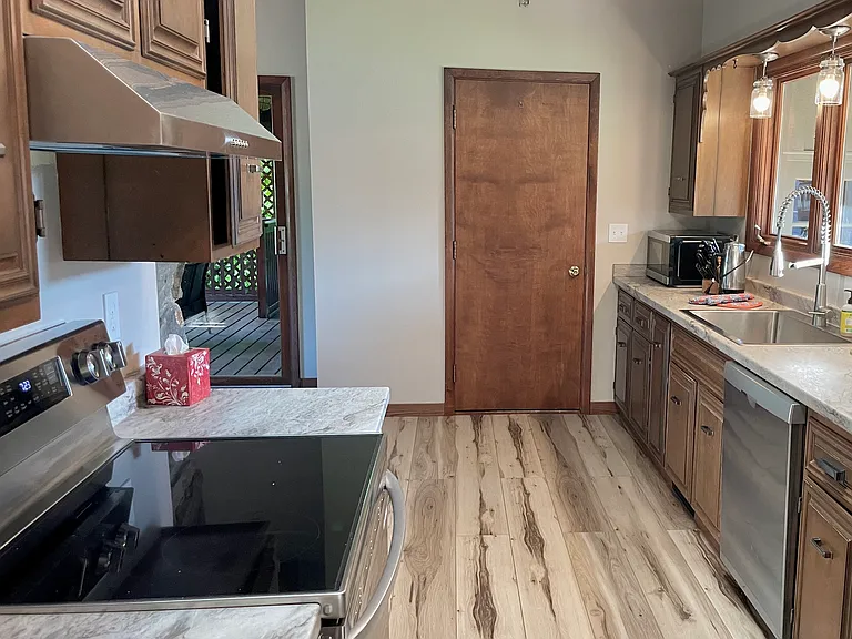 The kitchen area shows the walk-in door from the garage.