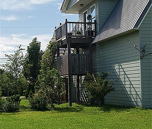 Entry is on second floor with balcony overlooking well manicured yard.