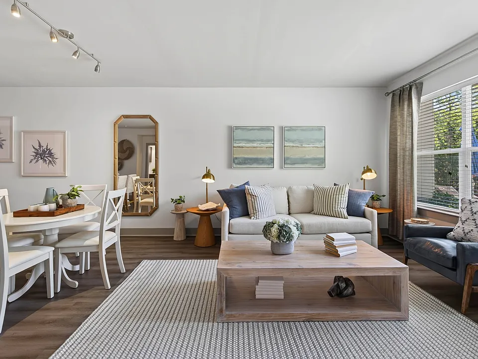 Large windows brighten the connected living and dining space throughout the day.