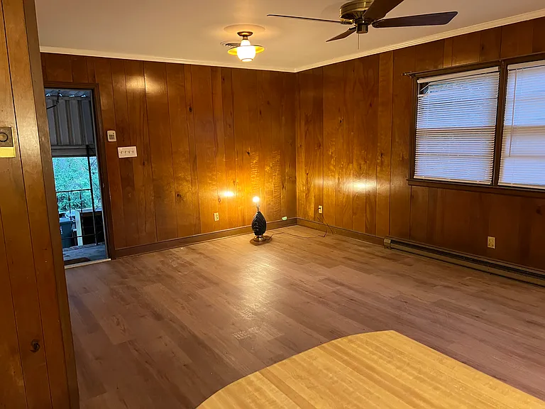 Large paneled den with just installed Luxury Vinyl Plank. Half bath near door. Side entrance to carport. New lighting being installed.