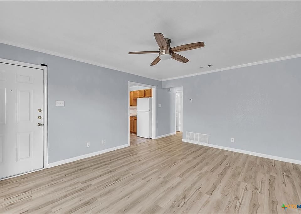 This spacious living room has 1 outlet on each wall (total of 4 outlets) and a remote-controlled fan/light.