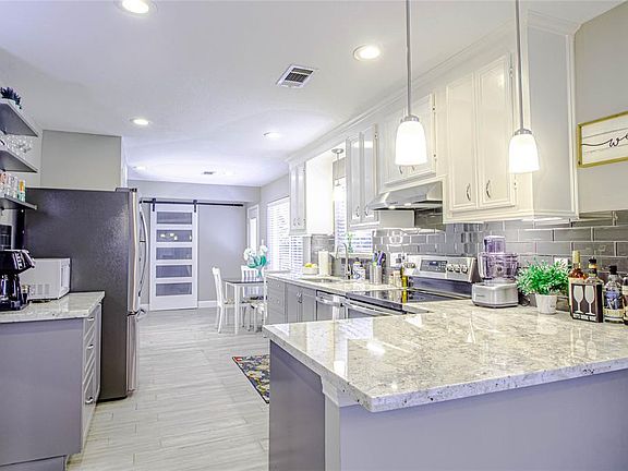 Modern Kitchen with exquisite selection of granite counter tops, two tone cabinet, subway tile, stainless steel appliances, extra recessed lighting, under-mounted lighting, Breakfast bar, coffee bar, surrounded by windows for extra natural light.