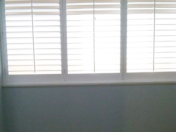 Loft is enclosed with half wall and white shutters