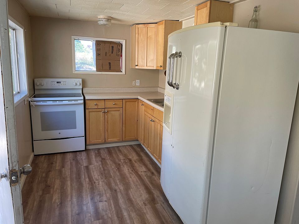 Bright kitchen with outside door access and adjacent dining area.
