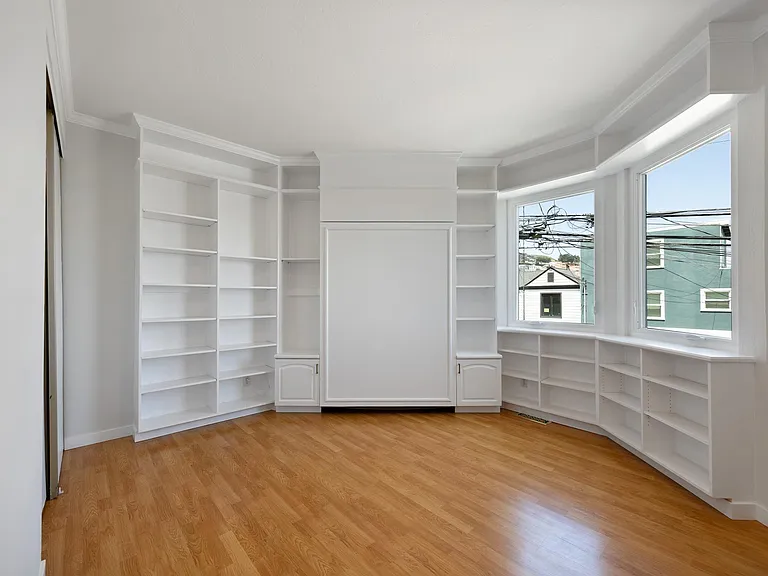 3rd bedroom with built-in shelving and full size murphy bed.