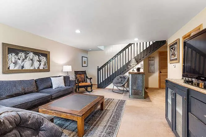 Lower level family room with TV, plus two additional bedrooms and bathroom.