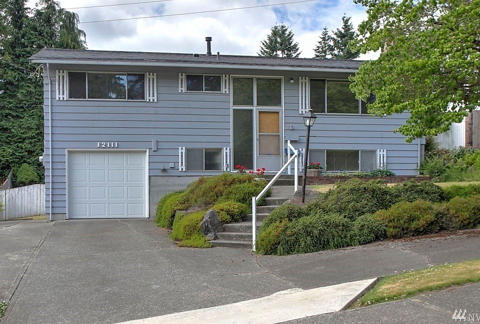 Welcome home to this spacious 4 bed, 2 bath home featuring a new roof, gleaming hardwoods, updated base trim, large windows and a gorgeous backyard. This location is ideally situated between both Tiffany Park and Cascade Park, and around the bend from Philip Arnold Park as well; three of this area's great places for recreation. The main living space is expansive and wonderful for gatherings. The kitchen offers lots of storage and a view of the backyard, featuring an entertainment sized covered patio, perfect for year-round use. You'll discover gorgeous flowerbeds with roses, lilies, rhubarb, blueberries, and lilac, plus a gate with access to a walking trail behind. All bedrooms and the living room  on the main floor feature lovely hardwood floors. On the lower floor you'll love the added bonus of a 4th bedroom, a rec room, 3/4 bath and a workshop!