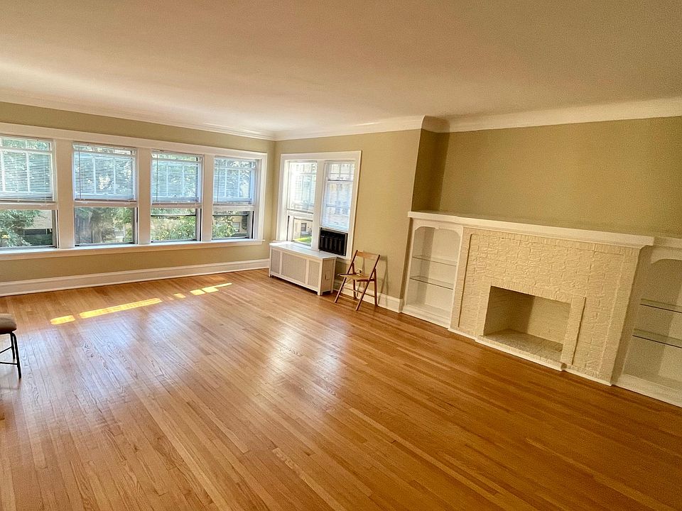 Huge sunny living room with decorative fireplace and built-in booksheves