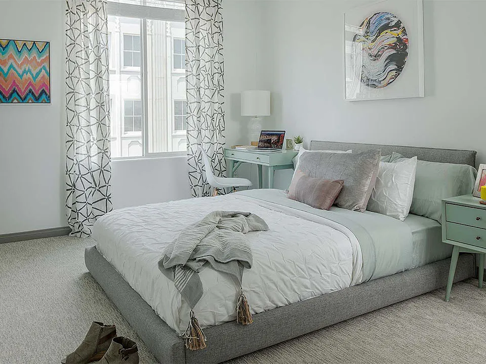 Spacious apartment bedroom with carpeted floors.