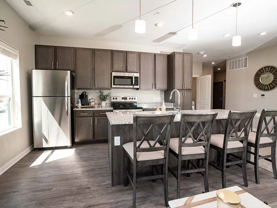 Large kitchen with island and seating at Heartland Flats Alliance.
