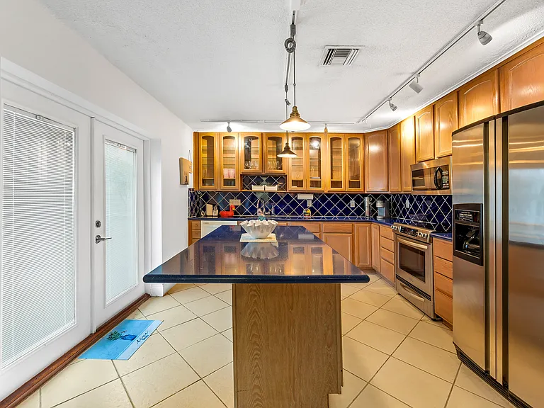 gorgeous kitchen with blue granite counters and island. leads to balcony