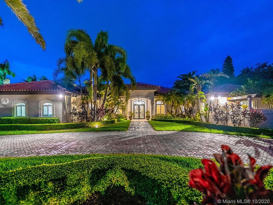 Lovely resort style home sits behind electronic gates on .9 acres in Pinecrest.