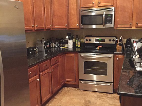 Kitchen with granite, stainless, and travertine flooring.