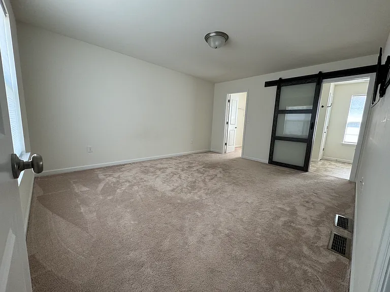 Primary bedroom with barn door access to bathroom